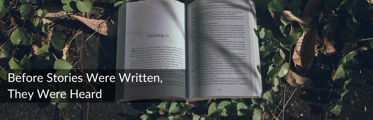 Open book resting on grass, symbolizing spoken storytelling before stories were written